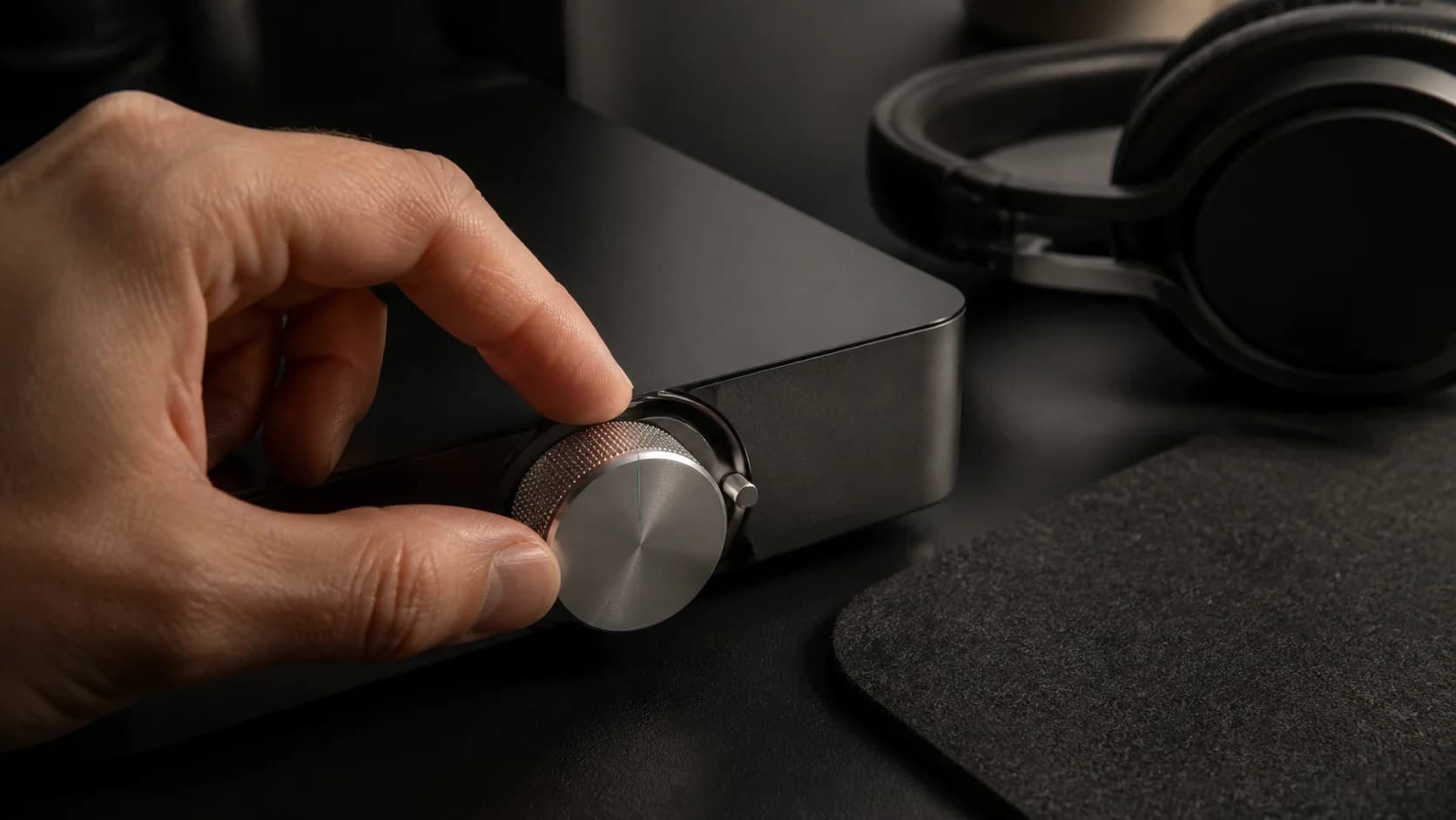A hand making a precise adjustment to a restrained silver volume control